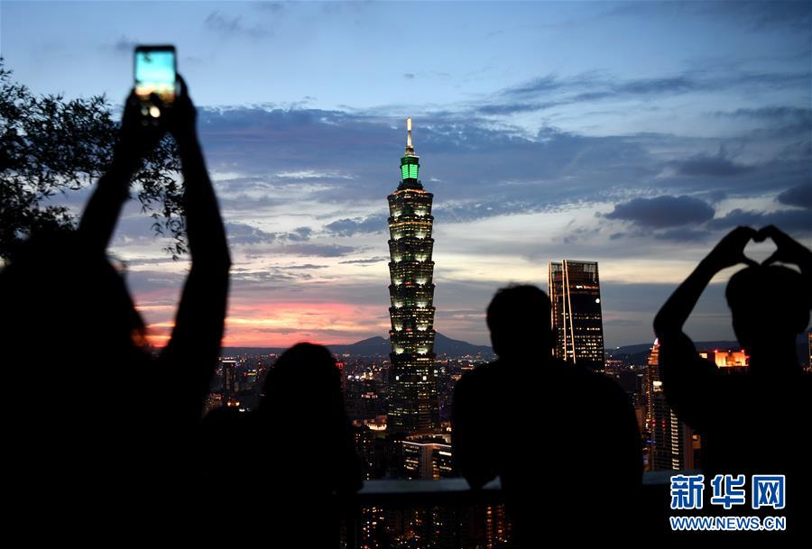 20日、臺(tái)北市の象山を訪れて市街地の寫真を撮る観光客（撮影?朱祥）。