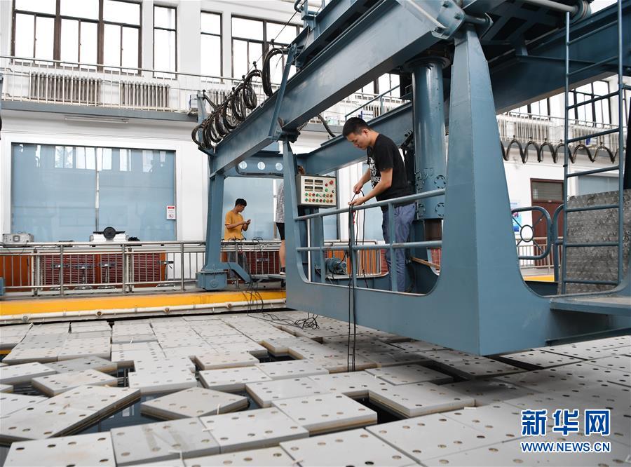 西北工業(yè)大學航海學院消音プール実験室で、実験裝置を調整中の學生（6月17日撮影?張博文）。