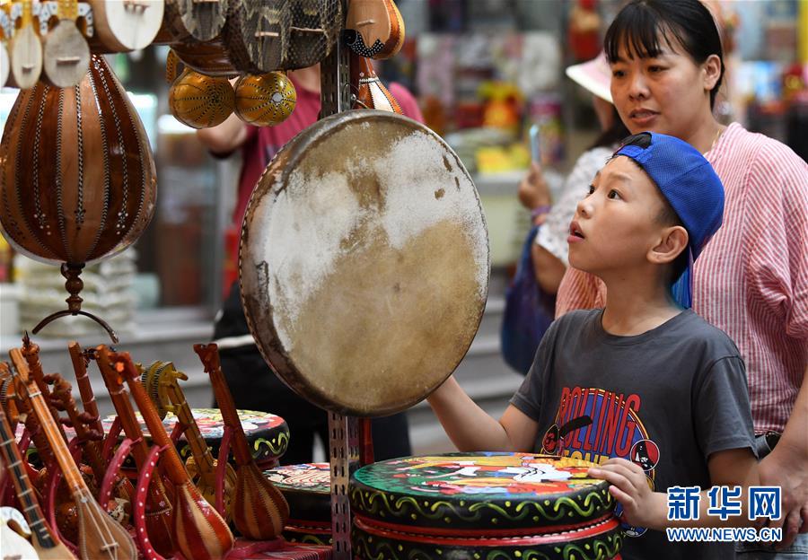 7月2日、大バザール景勝區(qū)でお土産を選ぶ子供（撮影?王菲）。