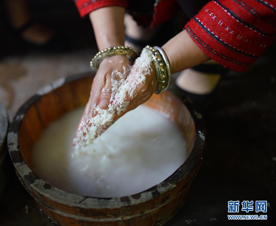 7月4日、広西チワン族自治區(qū)竜勝各族自治県竜脊鎮(zhèn)黃洛瑤寨で、米を研ぐ女性（撮影?黃勇丹）。