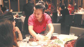 客に慣れた手つきでザリガニの殻を剝いてみせる従業(yè)員（撮影?喬然）。