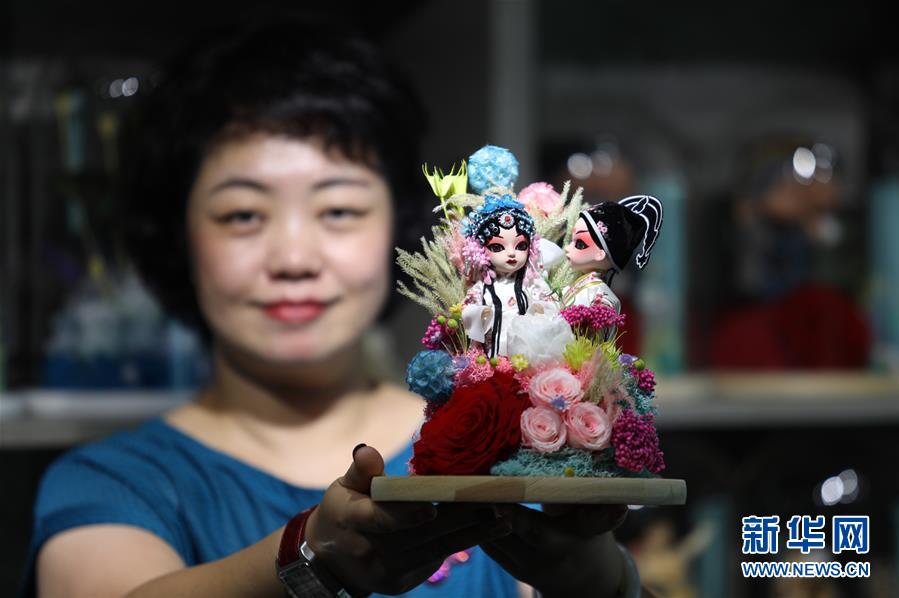 8月19日、プリザーブドフラワーと民間工蕓品を組み合わせた商品を見せる李虹さん（撮影?趙丹恵）。