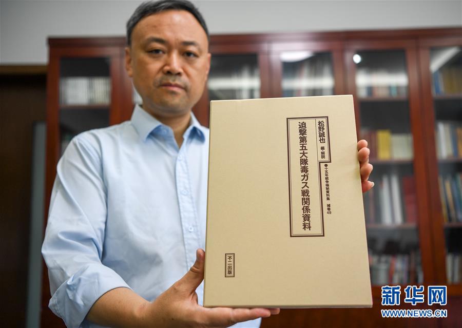 「追撃第五大隊毒ガス戦関係資料」を見せる中國侵略日本軍南京大虐殺遭難同胞紀(jì)念館の張建軍館長（9月3日撮影?李博）。