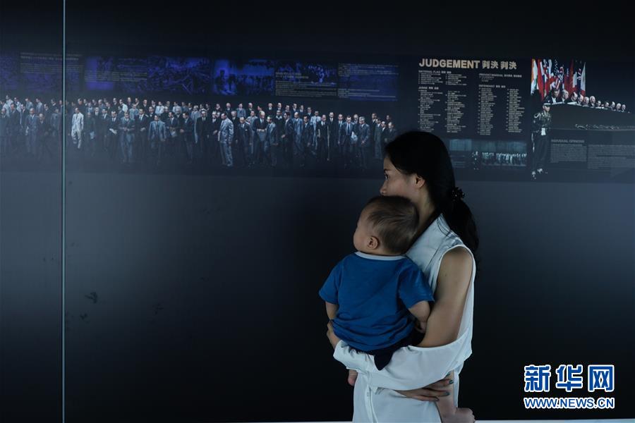 中國侵略日本軍南京大虐殺遭難同胞紀(jì)念館で寫真展を見學(xué)する人（撮影?季春鵬）。  