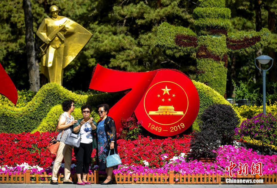 9月24日、新疆ウイグル自治區(qū)ウルムチ市人民公園內(nèi)で、「新中國成立70周年」をテーマにした花壇の前で記念寫真を撮る市民（撮影?劉新）。