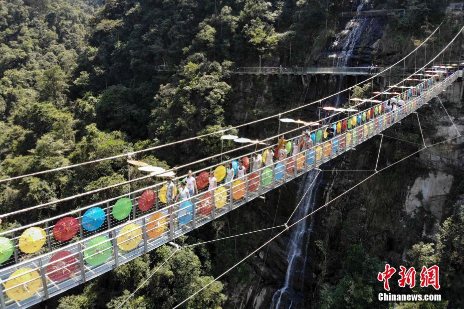 天空の橋でカラフルな傘とチャイナドレスのショー　湖南省九竜江