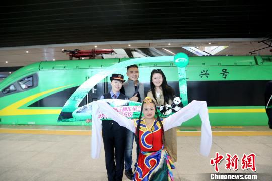 10月15日、「緑巨人」の発車前に、民族衣裝に身を包んだ乗務(wù)員と記念撮影をする乗客（撮影?陶靜）。