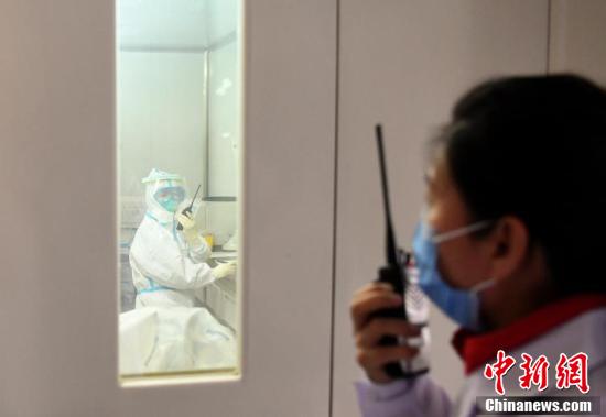 レシーバーを使い、検査室內(nèi)のスタッフと連絡(luò)をとる検査グループの張偉宏副グループ長(zhǎng)。