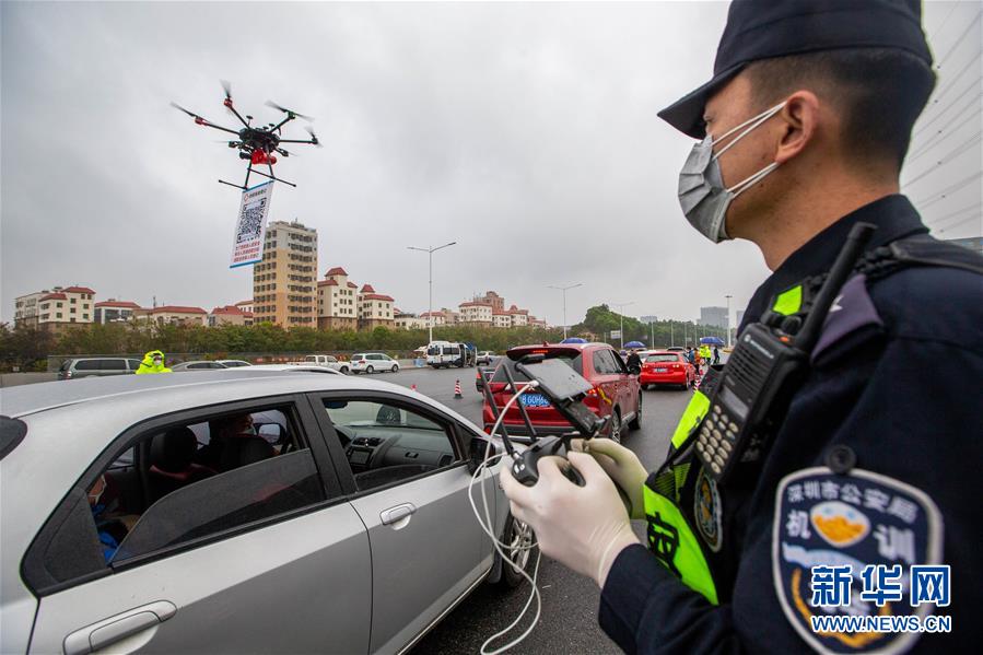 2月11日、G94高速深セン観瀾料金所で、登録用のQRコードをぶら下げたドローンを操縦して、ドライバーに登録するよう呼び掛ける深セン竜華機訓(xùn)大隊の警察官（撮影?頼犁）。