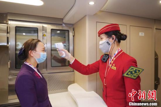 2月28日夜、威海発北京南行きG470號車の車內(nèi)で、食堂車乗務員の體溫を測定する車掌長（撮影?賈天勇）。