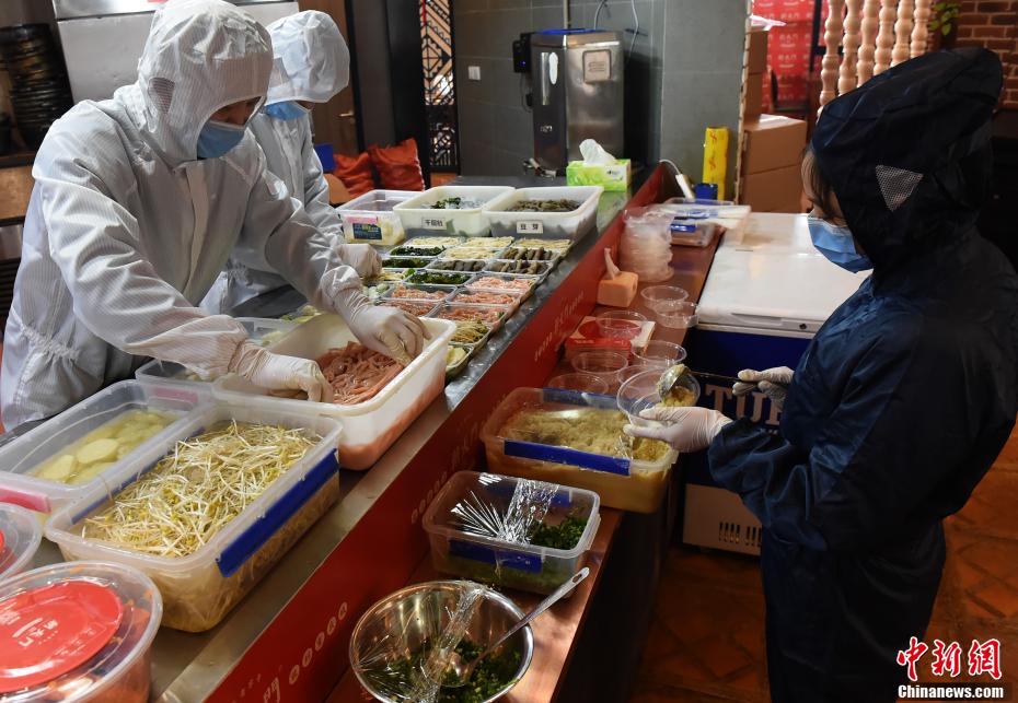 新型コロナウイルスと第一線で闘う醫(yī)療従事者の家族のためにお持ち帰り用火鍋セットを準(zhǔn)備する従業(yè)員3人（撮影?周毅）。