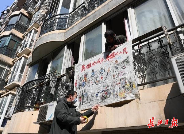 武漢頑張れ！「英雄都市」を描いた布をベランダに掲げる武漢市民