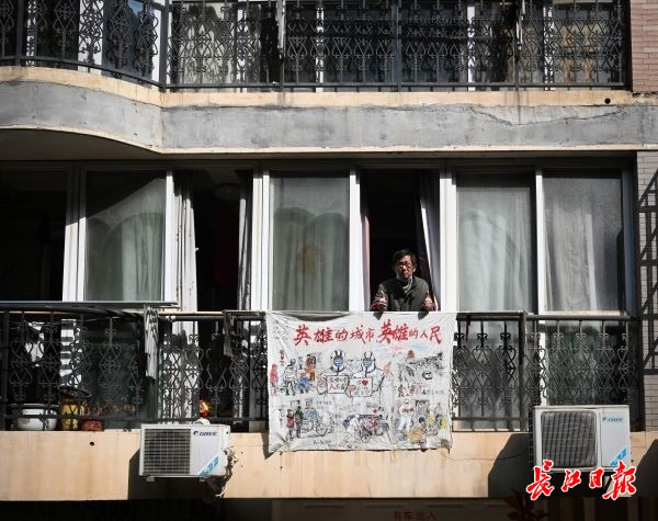 武漢頑張れ！「英雄都市」を描いた布をベランダに掲げる武漢市民