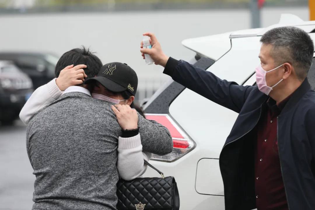 3月24日、武漢駅で、泣きながら抱き合う孟世奇さんと母親。傍らで母子にアルコール消毒液を吹きつける父親。武漢封鎖直前、市外の同級(jí)生の家に遊びに行っていたため武漢に戻れなくなってしまい、2ヶ月あまり足止めとなった後、ついに武漢に帰ることができたという中南財(cái)経政法大學(xué)に在學(xué)中の孟世奇さん（撮影?劉宇）。