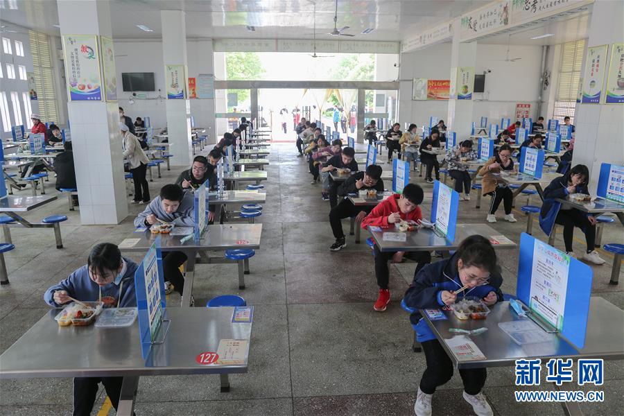 授業(yè)再開後、學(xué)食で「距離を取って食事をする」生徒たち　湖南