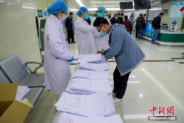 4月11日、湖北省中醫(yī)學(xué)病院光谷（オプティカル?バレー）院區(qū)職員の案內(nèi)で、登録?予備審査?問診を受ける健康診斷受診者（撮影?張暢）。