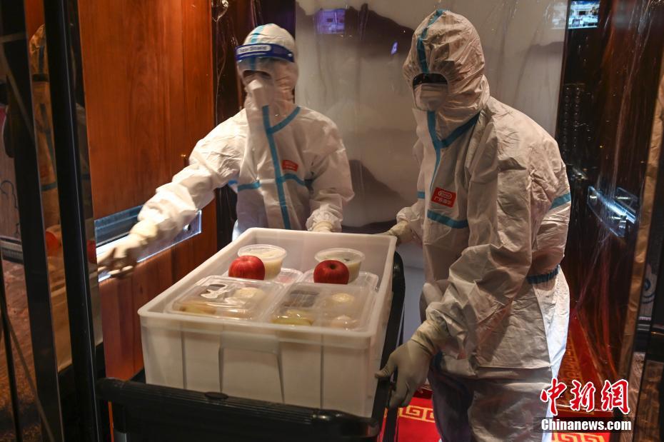 4月18日、広東省広州市黃埔區(qū)広州科學(xué)城本部國(guó)際ホテルで、隔離対象者の部屋に朝食を運(yùn)ぶ、外國(guó)人ボランティアのRUFINO EUGENIO GUILHERMEさん（寫真右） （撮影? 陳驥旻）。