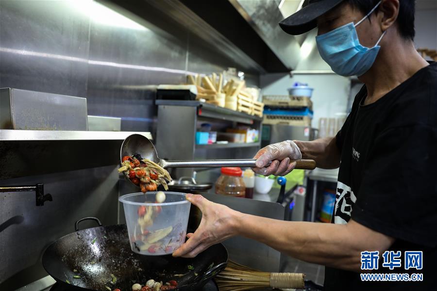 4月22日、「1回の配送料で複數(shù)のレストランの同時(shí)注文可能」キャンペーンに參加しているオーストラリア?キャンベラの火鍋店で料理を作る調(diào)理人（撮影?儲(chǔ)晨）。