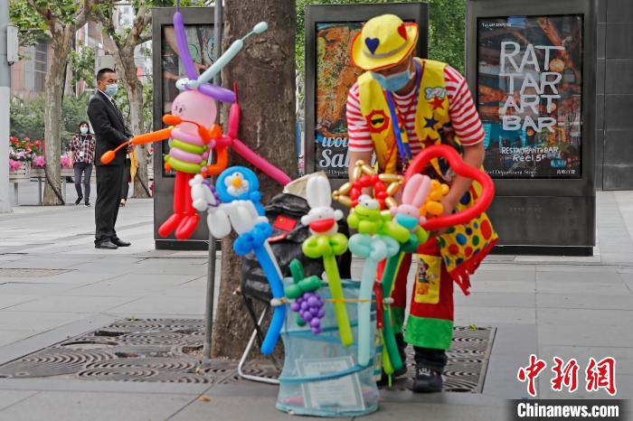 靜安寺商業(yè)エリアでマスクを著用してパフォーマンスを行う大道蕓人（撮影?殷立勤）。