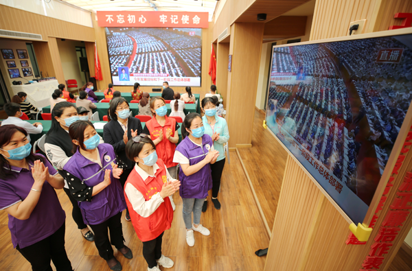 5月22日、山東省東営市東営區(qū)文匯街道（居住區(qū)）黨群サービスセンターで、第13期全人代第3回會議の開幕式を見るコミュニティ住民（撮影?劉智峰/人民図片）。