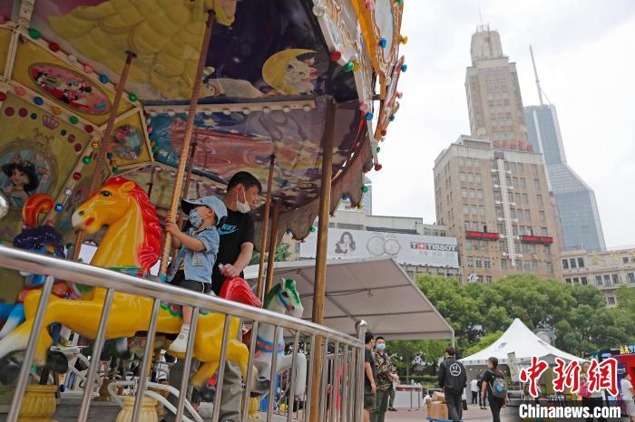 南京東路歩行者天國で、メリーゴーランドに乗る親子連れ（5月29日撮影?殷立勤）。