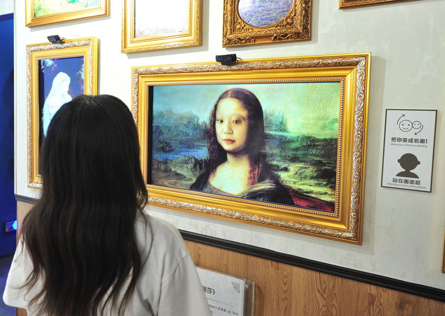 絵畫の中の人物と自分の顔を入れ替える來館者（資料提供?寫真著作権はCFP視覚中國が所有のため転載禁止）。