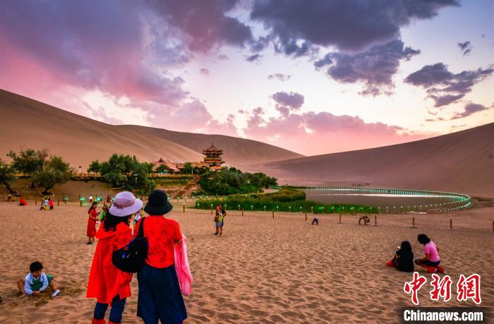 月牙泉の美しい夕焼けの風(fēng)景を鑑賞する観光客（撮影?王斌銀）。