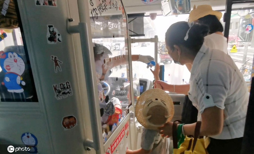 ドラえもんのキーホルダーを受け取る乗客の子供（寫(xiě)真著作権は東方ICが所有のため転載禁止）。