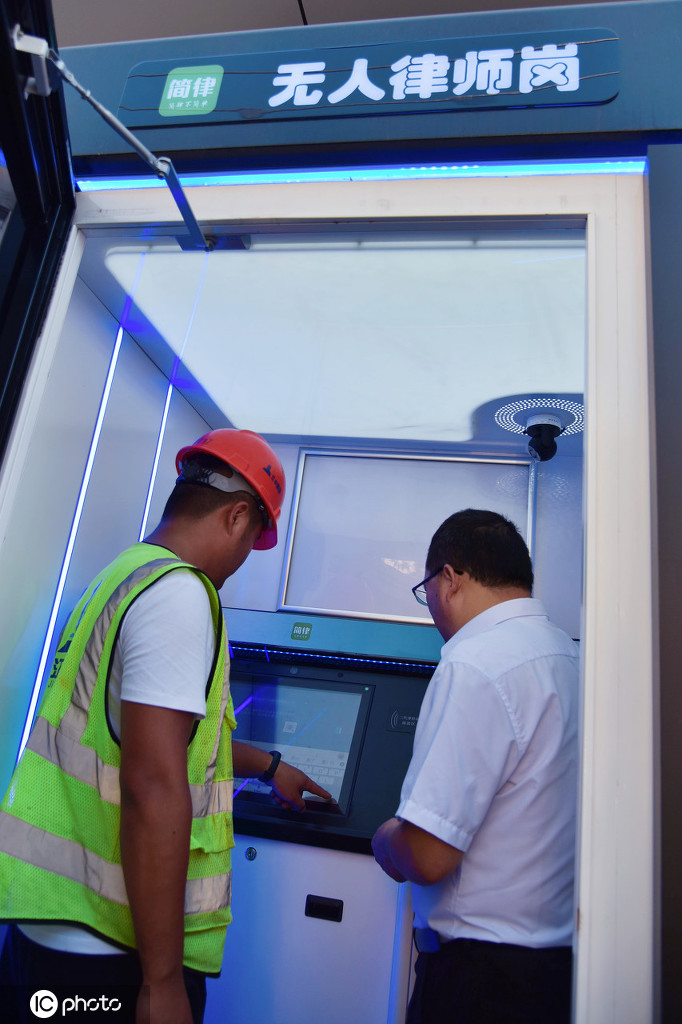 8月3日、江蘇省如皋市如城司法所スタッフに案內(nèi)されながら、「無(wú)人弁護(hù)士コーナー」を利用して法律知識(shí)に関する相談を進(jìn)める建設(shè)作業(yè)員（寫真左、寫真著作権は東方ICが所有のため転載禁止）。