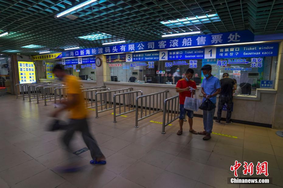 ?？诟郅违榨Д戛`乗り場のチケット売り場で、欠航前の最終便のチケットを買い、走ってフェリーに向かう男性（撮影?駱雲(yún)飛）。