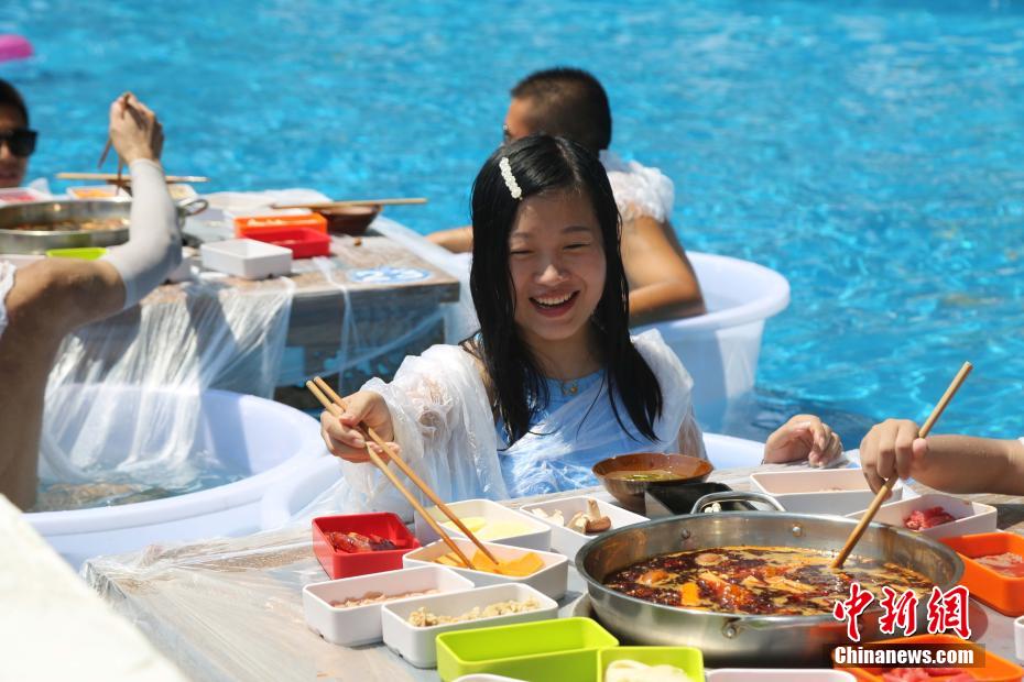 氷入りのバケツにつかり、アツアツの火鍋を食べる市民（撮影?楊孝永）。