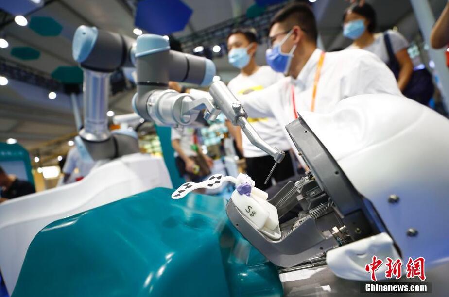 來(lái)場(chǎng)者の注目を集める口腔移植手術(shù)ロボット。（撮影?富田）