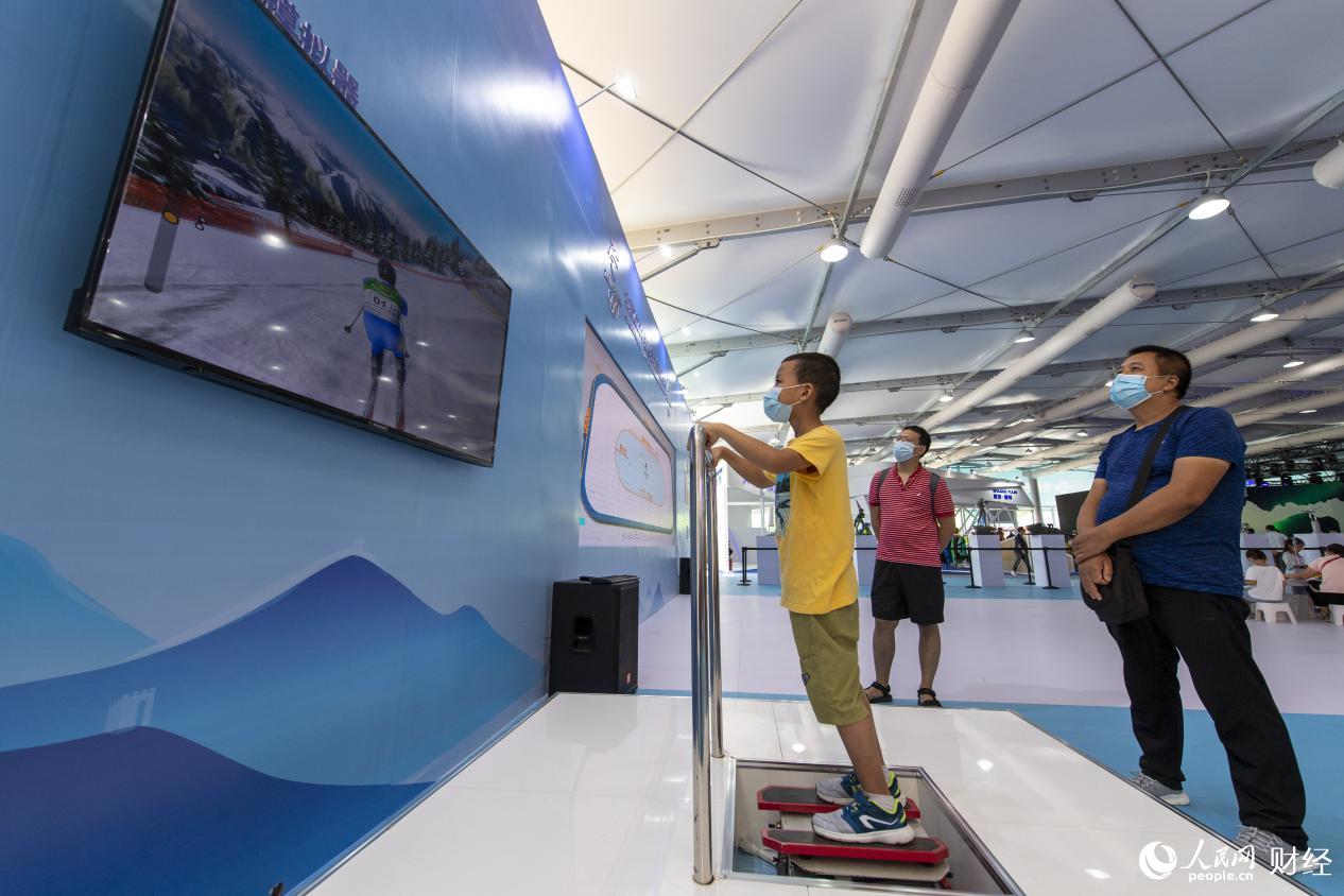 ウィンタースポーツコーナーで、スキーシミュレーション體験をする子供（撮影?翁奇羽）。