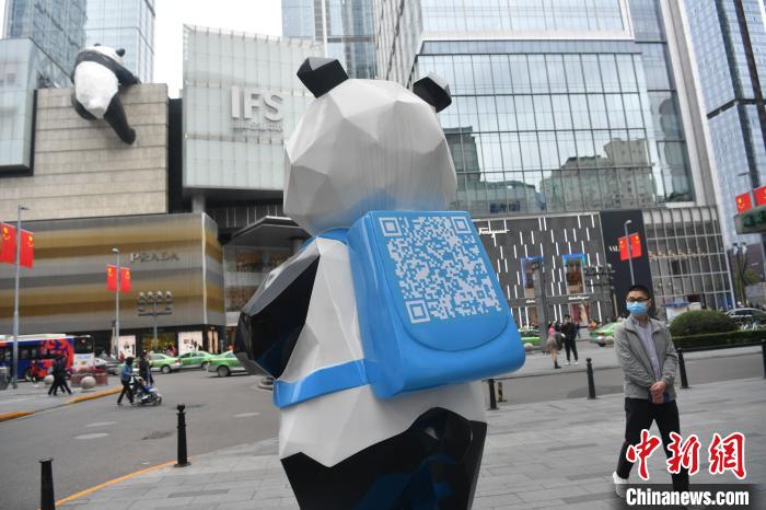 「壁をよじ登るパンダ」を眺める、新しく完成したパンダのオブジェ（撮影?張浪）。