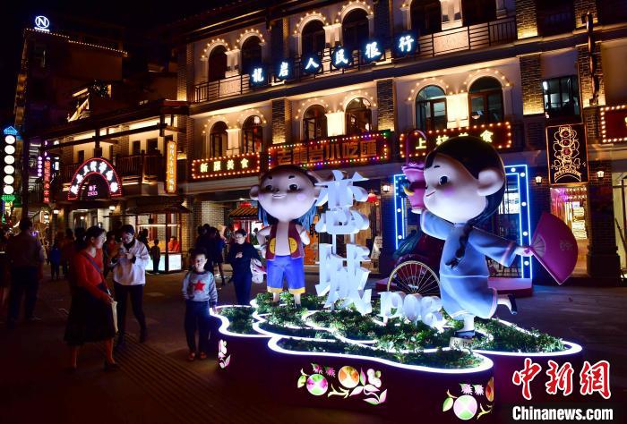 福建省竜巖市の市街地にある「中央蘇區(qū)金融街?戀城1908文化クリエイティブ?パーク街區(qū)」を訪れ、記念撮影に勤しむ多くの市民や観光客（撮影?張斌）。