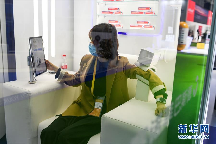 醫(yī)療機器?醫(yī)薬保健展示エリアのサノフィパスツール社の展示ブースで、スマート無人ワクチン接種モジュールのデモを行うスタッフ（11月7日撮影?李任滋）。