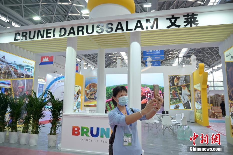 11月25日、広西チワン族自治區(qū)南寧國際コンベンションセンターのアセアン國家館で記念寫真を撮影する出展業(yè)者（撮影?兪靖）。