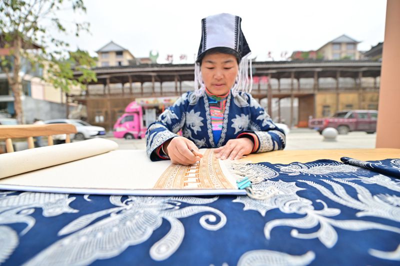 貴州省従江県で週末に行われた無形文化遺産と貧困者支援マーケットで、ろうけつ染め技術(shù)の実演を行うろうけつ染め職人（撮影?呉徳軍）。