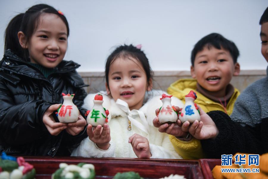 1月5日、「明けましておめでとう」という文字入りのお餅を見せる子供たち（撮影?徐昱）。