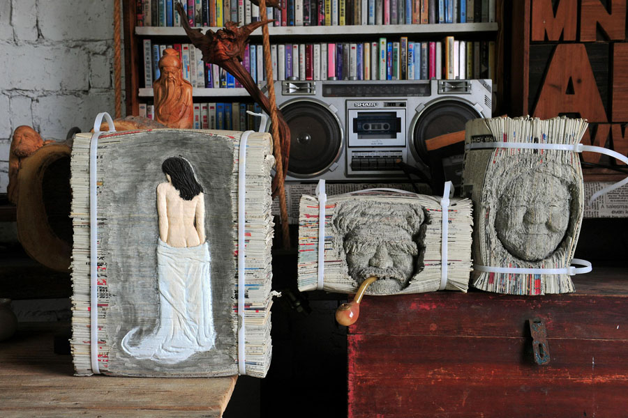 王偉挺さんが一括りにした古新聞に人物を彫った作品（寫真著作権はCFP視覚中國が所有のため転載禁止）。