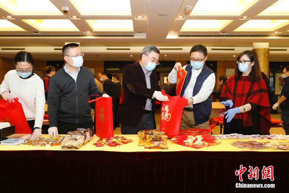 「春節(jié)セット」を詰める黃屏総領(lǐng)事（寫真中央）と銭進(jìn)副総領(lǐng)事（寫真右から2番目、寫真は在ニューヨーク中國総領(lǐng)事館が提供）。