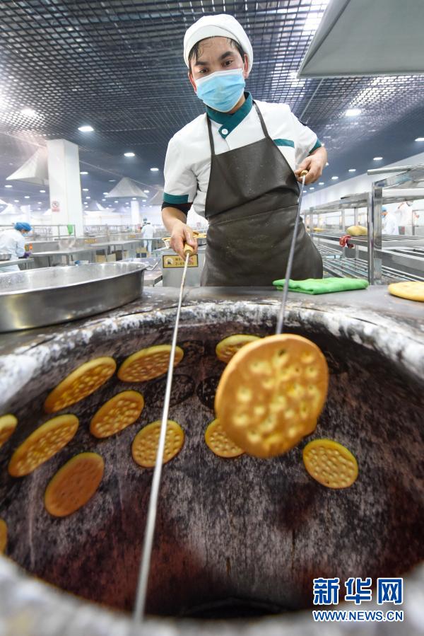 2月5日、霍爾果斯ナン産業(yè)園の生産現(xiàn)場でナンを焼く作業(yè)員（撮影?丁磊）。