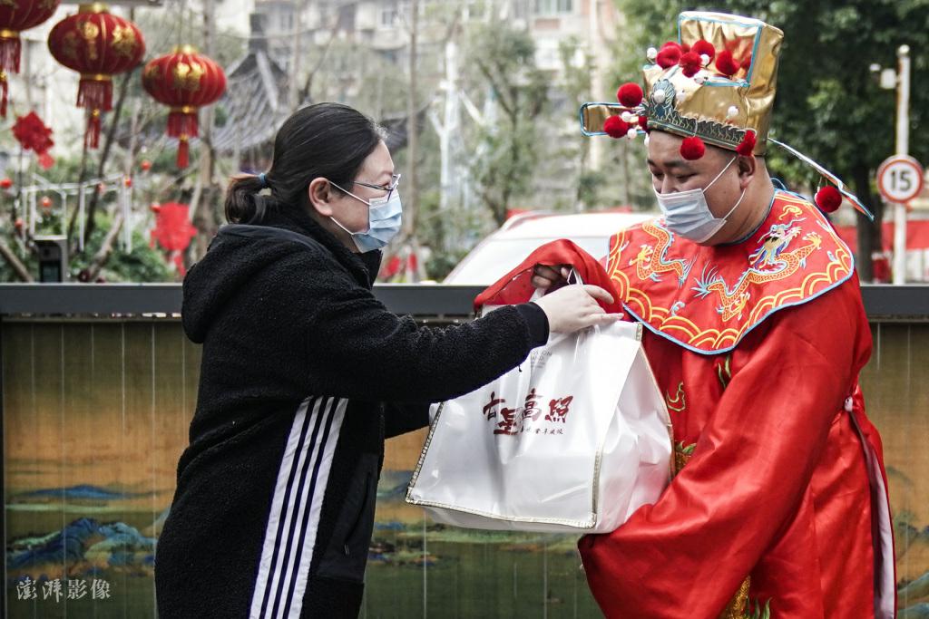 春節(jié)連休中に食事宅配の予約注文をした市民に食事と祝福を?qū)盲堡俊肛?cái)神」の衣裝を著た従業(yè)員（寫(xiě)真著作権は澎湃影像が所有のため転載禁止）。