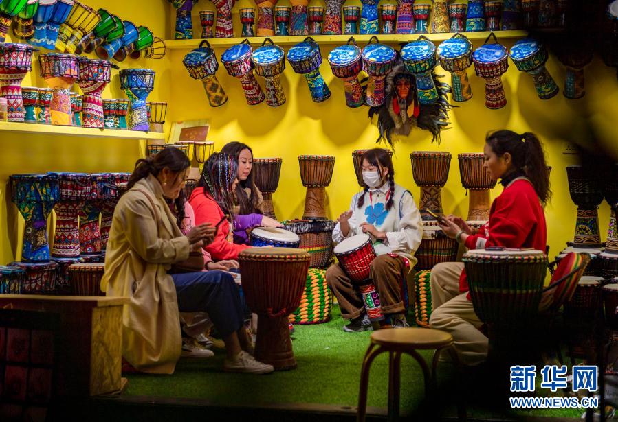 3月3日、大理古城で、打楽器のジャンベを體験する観光客（撮影?陳欣波）。