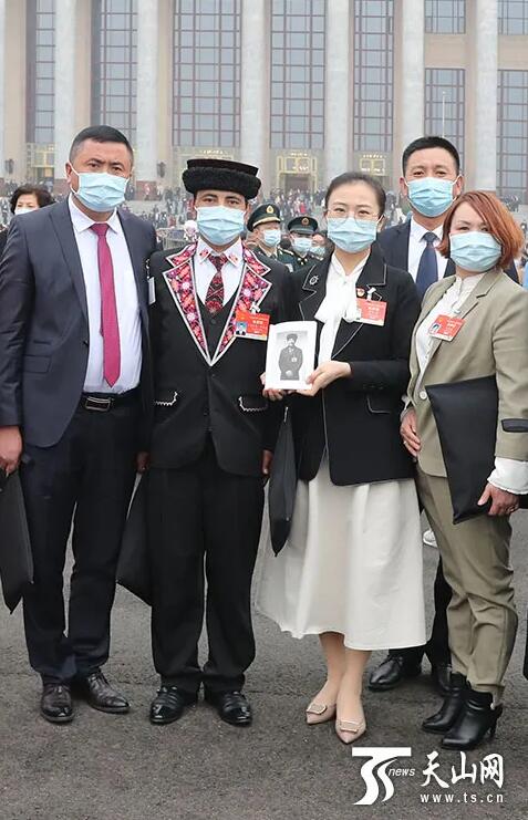3月5日、第13期全人代第4回會(huì)議に出席し、拉斎尼氏の遺影を手に人民大會(huì)堂前で記念撮影する木沙江?努爾●氏、崔久秀氏、麥麥提?居馬氏、多來(lái)提曼?開(kāi)米克氏ら（撮影?崔志堅(jiān)）。