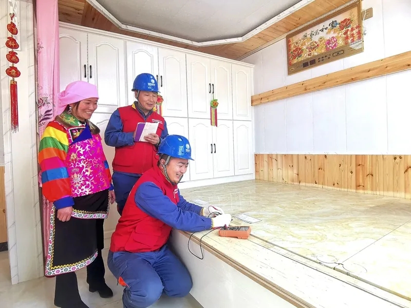 班彥新村の村民の家で電気式オンドルの電気使用狀況をチェックする電力會(huì)社のスタッフ（撮影?李永鵬）。