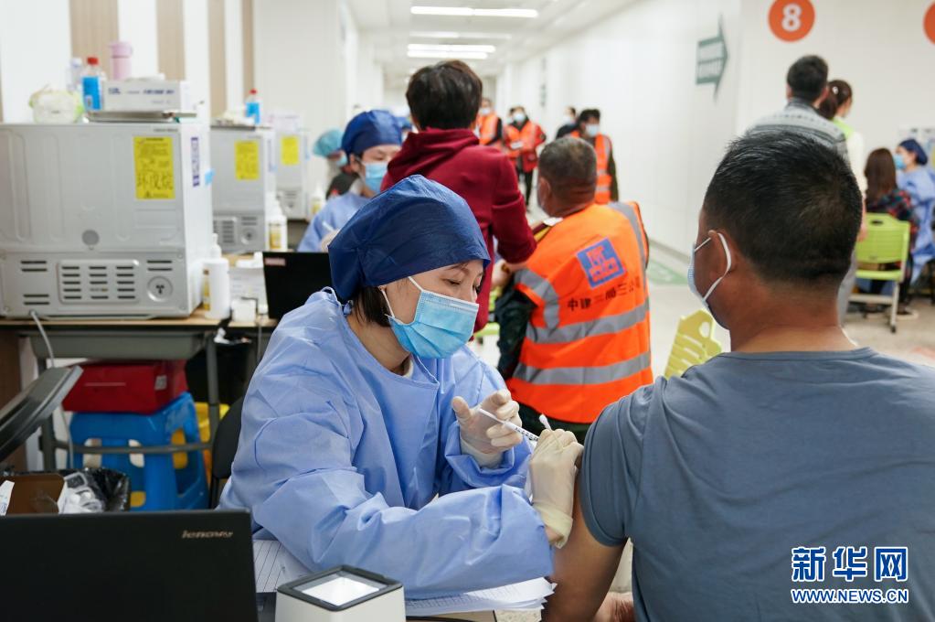 4月6日、上海市奉賢區(qū)の新型コロナウイルスワクチン臨時集団接種會場で、建設(shè)作業(yè)員にワクチンを接種する醫(yī)療関係者（撮影?丁?。?。