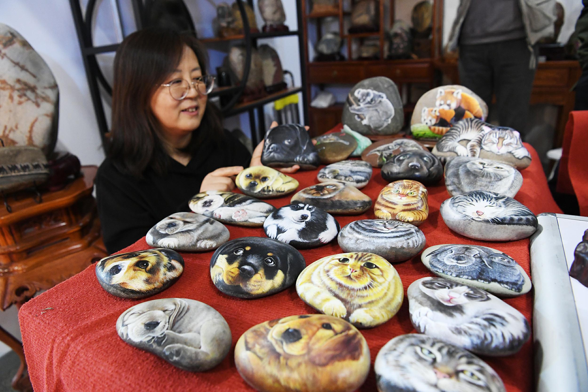 4月7日、自らが石に描いた絵を見(jiàn)せる中學(xué)?高校教員の馬玉蘭先生（寫(xiě)真著作権はCFP視覚中國(guó)が所有のため転載禁止）。