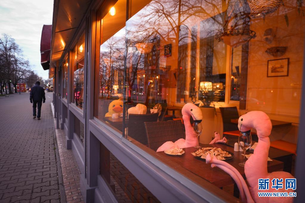 4月13日、人々の関心を集めるため、動(dòng)物のぬいぐるみを窓際の座席に座らせているポーランドの首都ワルシャワにあるレストラン。