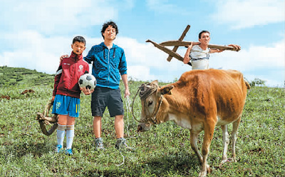 ドキュメンタリー「走近大涼山」の中で男児と肩を組む竹內(nèi)氏（寫真中央、畫像は中國外文局提供）。